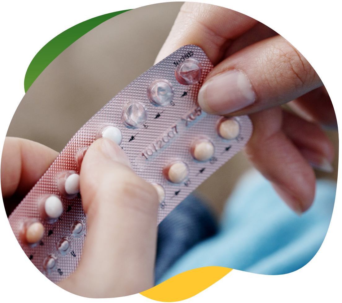 Moters ranka, išspaudžianti iš pakuotės kontraceptinę piliulę